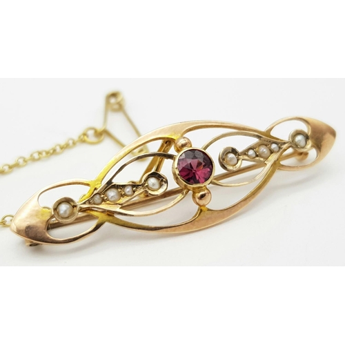 219 - An Antique 9k Yellow Gold Pearl and Ruby Brooch with Safety Chain. 4.5cm. 2.7g total weight.