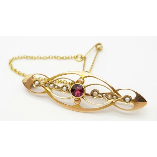 219 - An Antique 9k Yellow Gold Pearl and Ruby Brooch with Safety Chain. 4.5cm. 2.7g total weight.