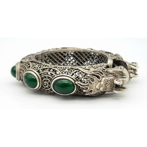 450 - A Tibetan Silver Double Dragon Statement Bracelet with Green Jade Cabochon Decoration. Tells the sto... 