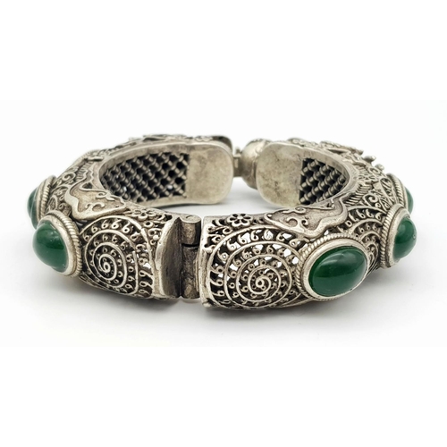 450 - A Tibetan Silver Double Dragon Statement Bracelet with Green Jade Cabochon Decoration. Tells the sto... 