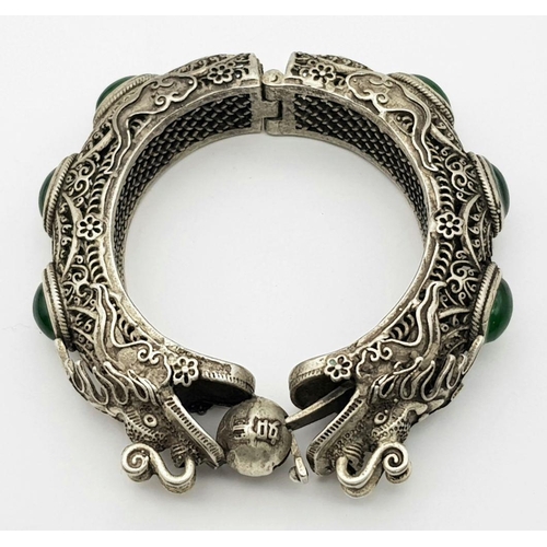 450 - A Tibetan Silver Double Dragon Statement Bracelet with Green Jade Cabochon Decoration. Tells the sto... 