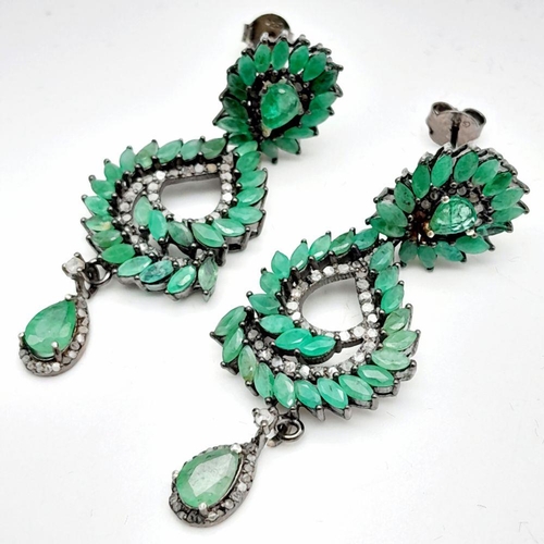 112 - An vintage sterling silver pair of earrings with old cut diamonds and oval cut emeralds. In excellen... 