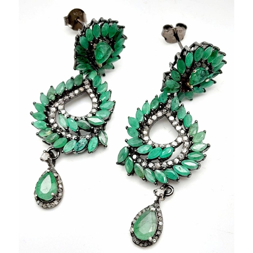 112 - An vintage sterling silver pair of earrings with old cut diamonds and oval cut emeralds. In excellen... 