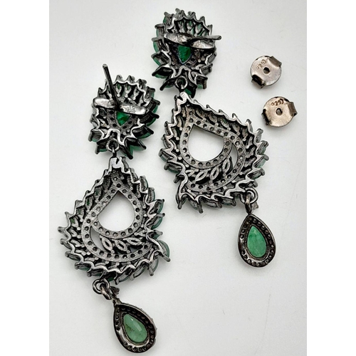 112 - An vintage sterling silver pair of earrings with old cut diamonds and oval cut emeralds. In excellen... 