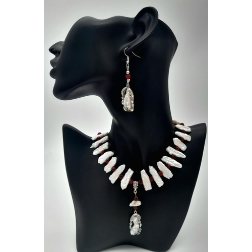 210 - A trend setting sterling silver pearl and ruby necklace and earrings set in a presentation box. The ... 