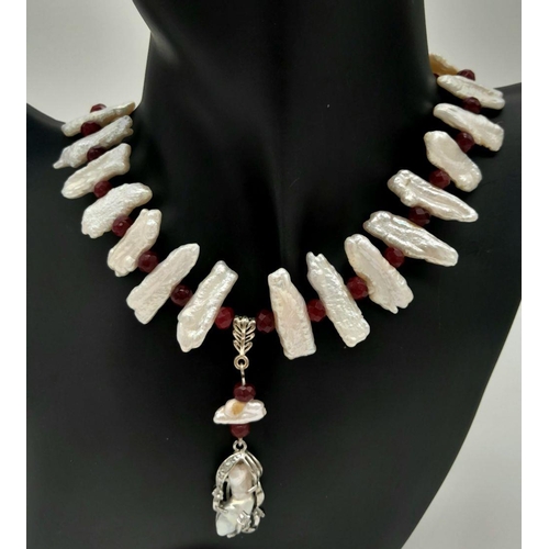 210 - A trend setting sterling silver pearl and ruby necklace and earrings set in a presentation box. The ... 