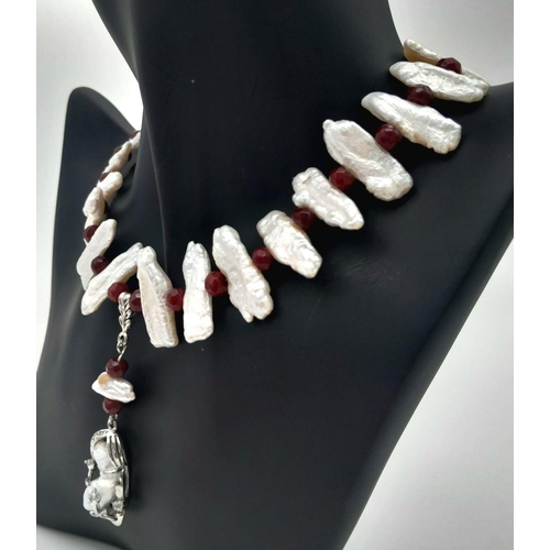 210 - A trend setting sterling silver pearl and ruby necklace and earrings set in a presentation box. The ... 