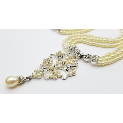 245 - A very elegant, vintage, three string faux pearl necklace with a sophisticated Art Nouveau pendant a... 