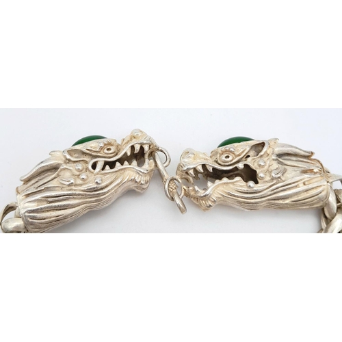 393 - A Tibetan Silver Double-Headed-Dragon Bracelet. Green Jade cabochon decoration. 20cm length.