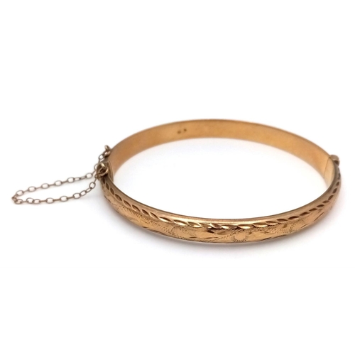 8 - A Vintage 9K Yellow Gold Bangle. Clip design with safety chain. 6cm inner diameter. 8.3g