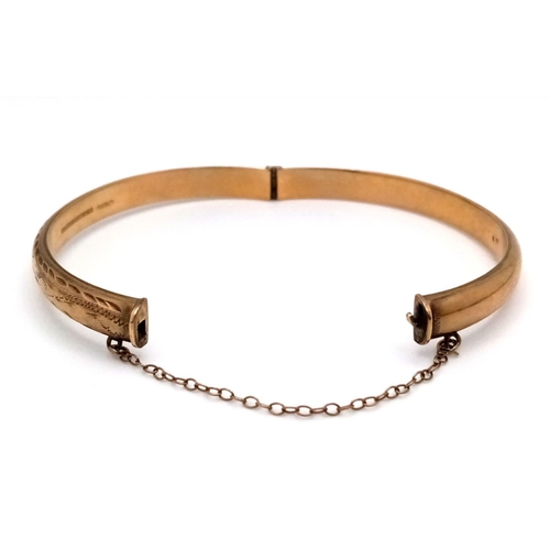 8 - A Vintage 9K Yellow Gold Bangle. Clip design with safety chain. 6cm inner diameter. 8.3g