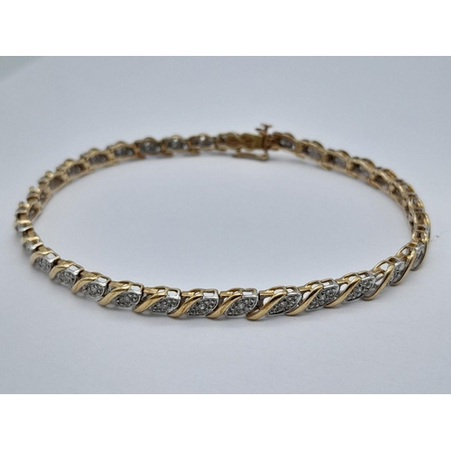 82 - A 9K YELLOW GOLD DIAMOND SET TENNIS BRACELET WITH SAFETY CATCH - 6.9G. 18CM. REF: SC4041