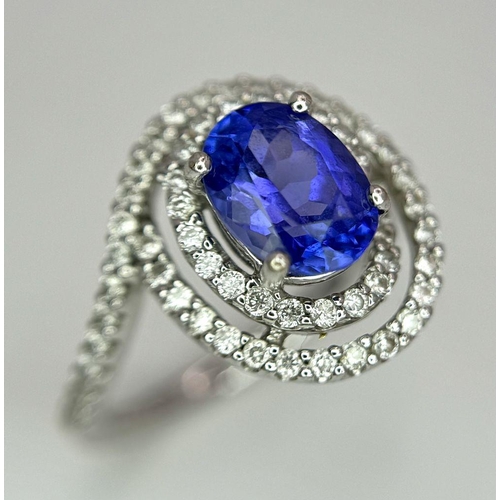 93 - AN 18K WHITE GOLD DIAMOND AND TANZANITE RING. 1.56CT OVAL TANZANITE AND 0.35CTW DIAMONDS. 4.4G. SIZE... 