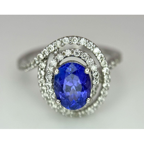 93 - AN 18K WHITE GOLD DIAMOND AND TANZANITE RING. 1.56CT OVAL TANZANITE AND 0.35CTW DIAMONDS. 4.4G. SIZE... 