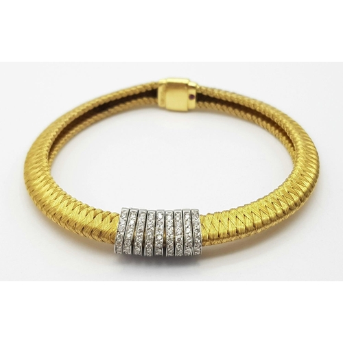 61 - AN 18K YELLOW GOLD DIAMOND SET BRACELET WITH A SERPENTINE WEAVED EFFECT - 0.60CTW. 23.4G. 
5.5CM INN... 