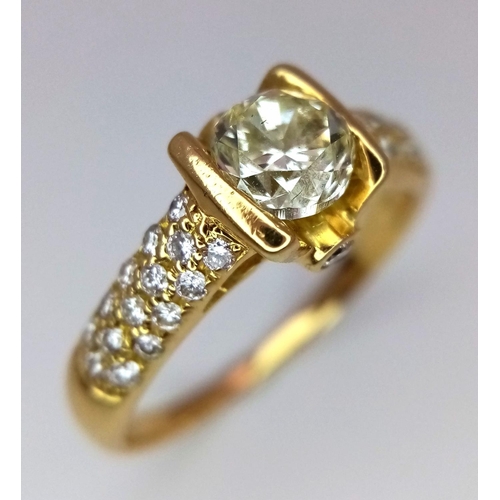 184 - An 18K Yellow Gold and Diamond Gents Dress Ring. A 1.044ct brilliant round cut centre diamond is acc... 