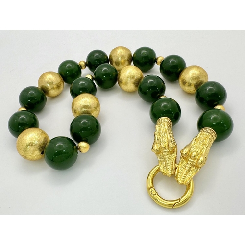 262 - A regal, dark green jade necklace with large gold-plated double Chinese dragon clasp and spacer bead... 