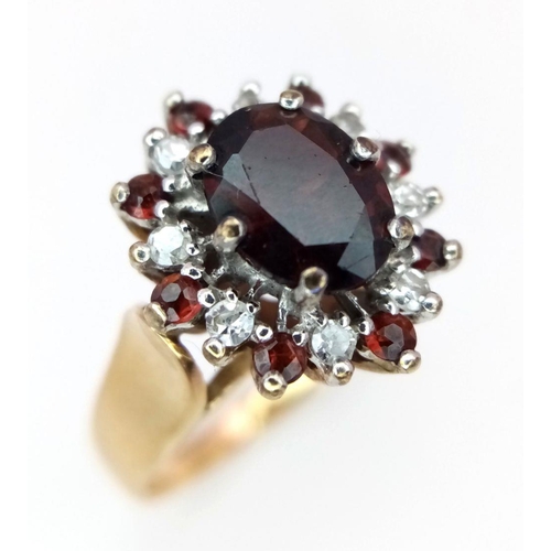 380 - A 9K Yellow Gold Garnet and Diamond Ring. Central oval garnet with diamond surround. Size J. 3.95g t... 