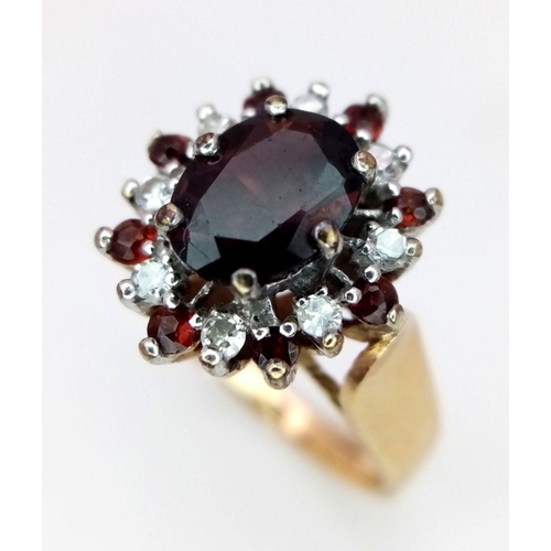 380 - A 9K Yellow Gold Garnet and Diamond Ring. Central oval garnet with diamond surround. Size J. 3.95g t... 