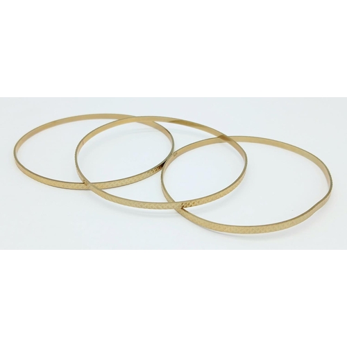 100 - A MATCHING SET OF 3 PATTERNED BANGLES IN 9K GOLD .   12.7gms