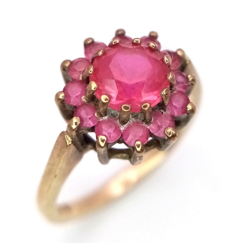 142 - A 9K GOLD RING WITH A CENTRAL PINK RUBY SURROUNDED BY PINK SAPPHIRES  .    2.7gms    size J