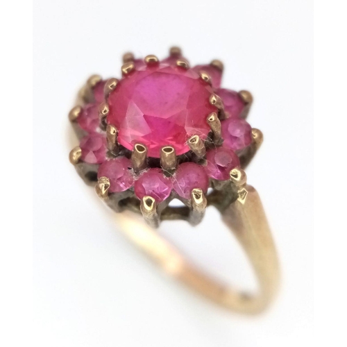 142 - A 9K GOLD RING WITH A CENTRAL PINK RUBY SURROUNDED BY PINK SAPPHIRES  .    2.7gms    size J