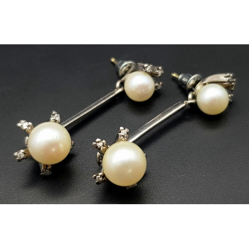 541 - A Pair of 18K White Gold, South Sea Pearl and Diamond Bar Drop Earrings. 16 petit brilliant round cu... 