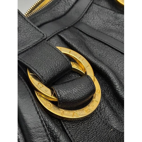 431 - A Bvlgari Black Polly Handbag. Black leather exterior with gold-toned hardware with two leather stra... 