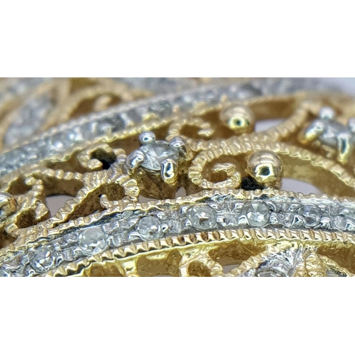 464 - A Majestic 14K Yellow Gold Diamond Encrusted Pendant. Pierced decoration with symmetrical diamond pl... 