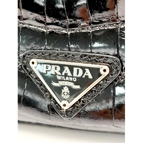 249 - A Prada Black Coccodrillo Evening Bag. Crocodile leather exterior with silver-toned hardware, textil... 