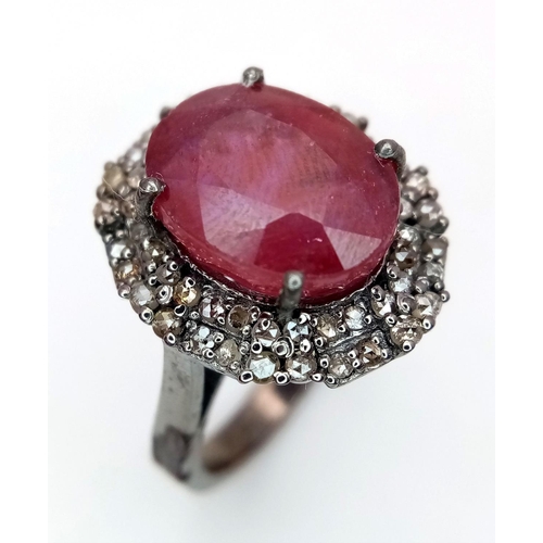 141 - A 6.35ct Oval Cut Ruby Ring with a 0.75ctw Diamond Surround - Set in 925 Silver. Size L. Comes with ... 