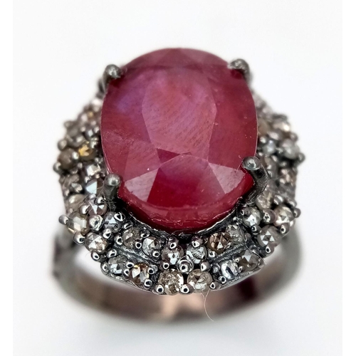 141 - A 6.35ct Oval Cut Ruby Ring with a 0.75ctw Diamond Surround - Set in 925 Silver. Size L. Comes with ... 