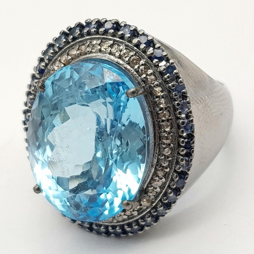 24 - A Mesmerising 10ct Blue Topaz Gemstone Ring with a 0.65ctw Diamond Surround set in 925 Silver. Size ... 