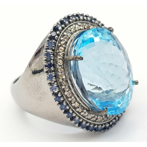 24 - A Mesmerising 10ct Blue Topaz Gemstone Ring with a 0.65ctw Diamond Surround set in 925 Silver. Size ... 