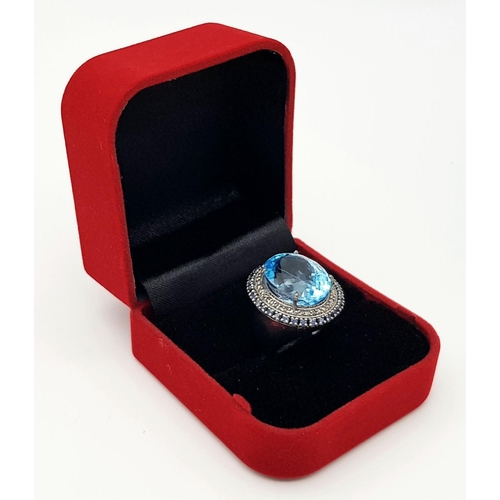 24 - A Mesmerising 10ct Blue Topaz Gemstone Ring with a 0.65ctw Diamond Surround set in 925 Silver. Size ... 