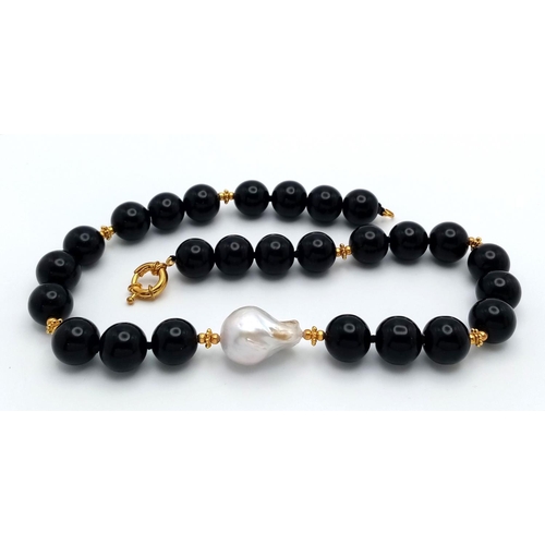 369 - A Mesmerising Black Onyx Beaded Necklace with White Baroque Pearl Interrupter. Gilded spacers and cl... 