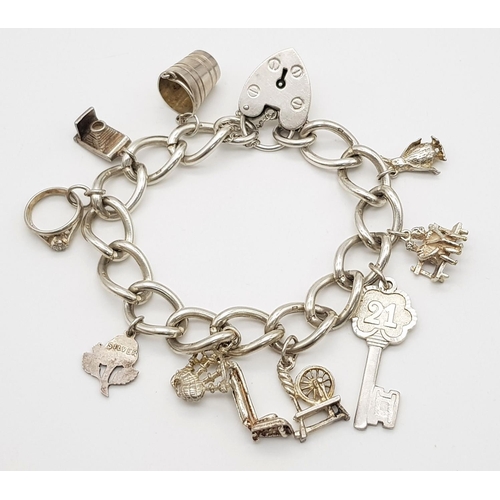 378 - Vintage SILVER CHARM BRACELET complete with safety chain. Charm to include spinning wheel ,bagpipes ... 