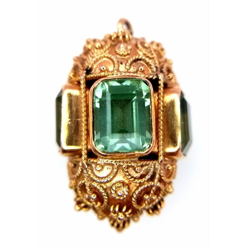 53 - An 18K Yellow Ornate Emerald Egg-Shaped Pendant. Five rectangular cut emeralds. Tests as 18k gold. 3... 