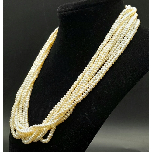 555 - An Eight Row Small Rondelle Pearl Necklace with a 9K Yellow Gold Shell Form Clasp. 42cm.