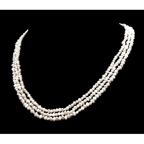 856 - A Three Row Petit Rice Pearl Necklace with 9k Gold Clasp. 40cm.