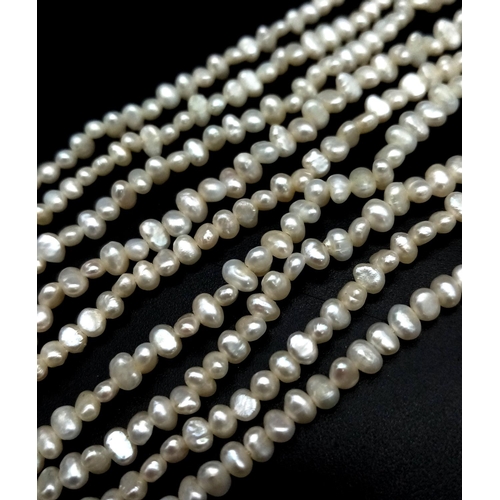 856 - A Three Row Petit Rice Pearl Necklace with 9k Gold Clasp. 40cm.