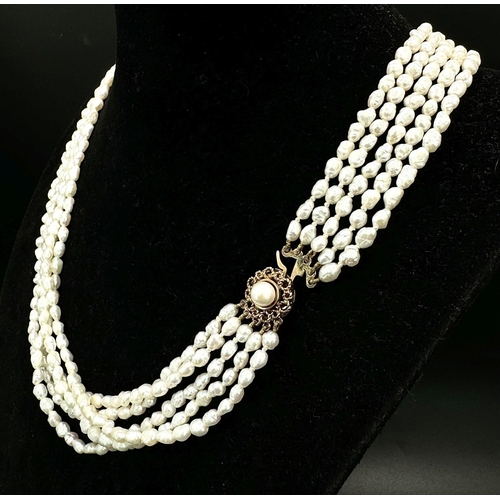 883 - A Five Row Rice Pearl Necklace with 9K Gold Clasp. 40cm.