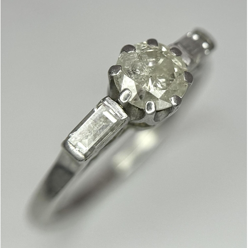 575 - A Platinum and Diamond Ring. Central 0.50ct diamond with baguette diamonds on shoulders. Size O. 4.8... 