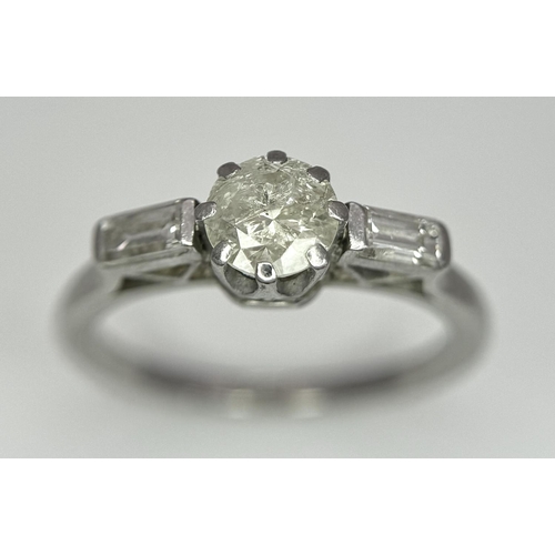 575 - A Platinum and Diamond Ring. Central 0.50ct diamond with baguette diamonds on shoulders. Size O. 4.8... 