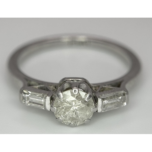 575 - A Platinum and Diamond Ring. Central 0.50ct diamond with baguette diamonds on shoulders. Size O. 4.8... 