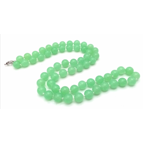 827 - A Light Green Jade Matinee Length Bead Necklace. 80cm necklace length. 12mm jade beads.