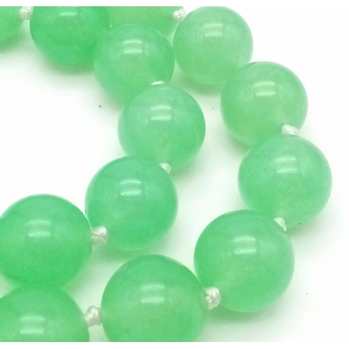 827 - A Light Green Jade Matinee Length Bead Necklace. 80cm necklace length. 12mm jade beads.