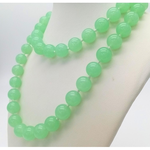 827 - A Light Green Jade Matinee Length Bead Necklace. 80cm necklace length. 12mm jade beads.