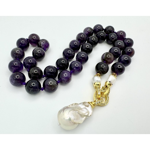 316 - A Deep Purple Amethyst Bead Necklace with a Baroque Pearl Drop Pendant. 12mm amethyst beads. Gilded,... 