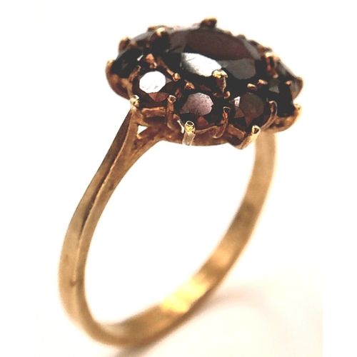 1142 - An 18K Yellow Gold Garnet Floral Cluster Ring. Size P, 3.69g total weight.